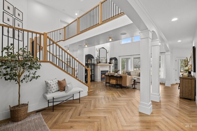 3031 Champagne Ct, Eagle, ID 83616 - foyer entrance with recessed lighting, a high ceiling, stairs, a tile fireplace, and ornate columns