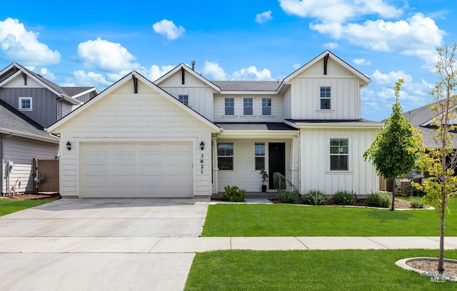 view of front facade with board and batten siding, concrete driveway, a front yard, and an attached garage
