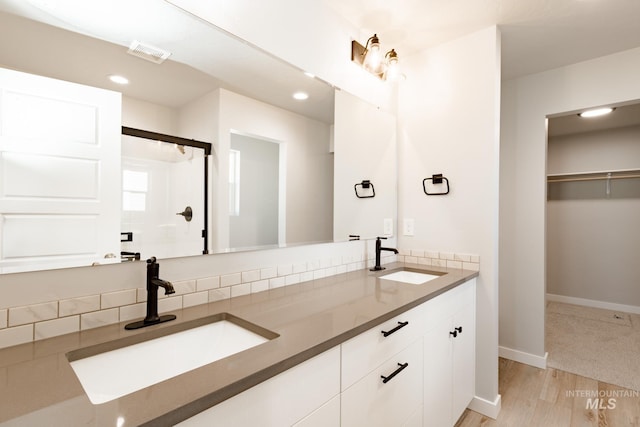 bathroom featuring vanity, a shower with shower door, and wood-type flooring