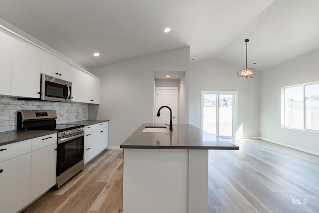 kitchen featuring vaulted ceiling, hanging light fixtures, sink, decorative backsplash, and stainless steel appliances