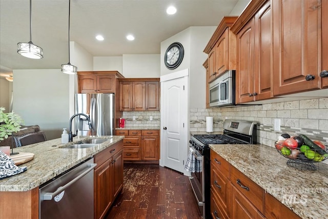 730 N Finsbury Way, Star, ID 83669 - kitchen with stainless steel appliances, light stone countertops, dark wood-type flooring, backsplash, and brown cabinets