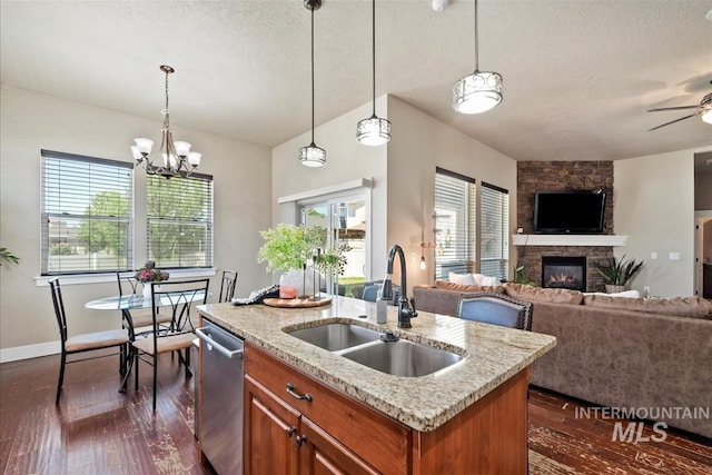 730 N Finsbury Way, Star, ID 83669 - kitchen featuring stainless steel dishwasher, open floor plan, brown cabinets, vaulted ceiling, and a fireplace