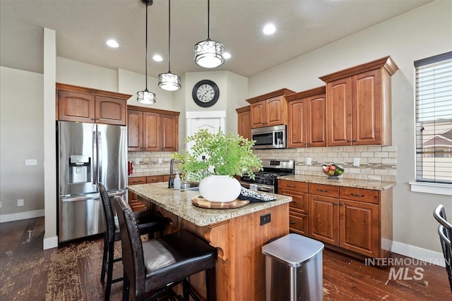 730 N Finsbury Way, Star, ID 83669 - kitchen featuring stainless steel appliances, an island with sink, backsplash, pendant lighting, and a breakfast bar area