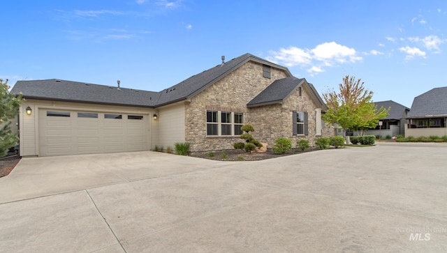 view of front of house with a garage, driveway, and stone siding