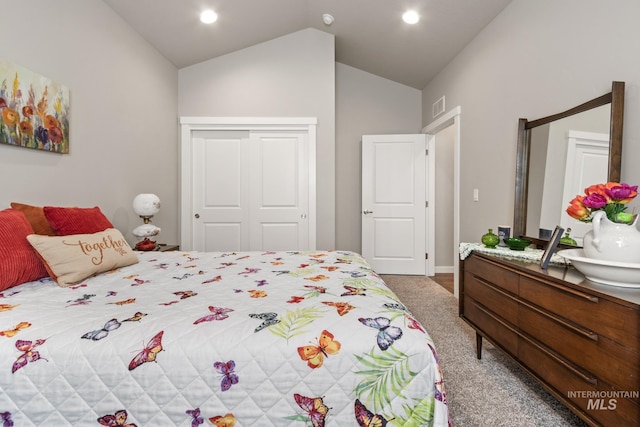 carpeted bedroom with baseboards, vaulted ceiling, visible vents, and a closet