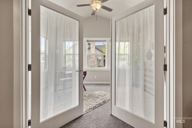 doorway to outside with baseboards, ceiling fan, carpet flooring, and lofted ceiling