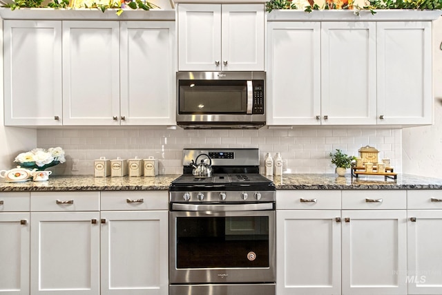 kitchen featuring tasteful backsplash, white cabinets, light stone countertops, and stainless steel appliances