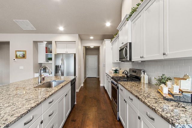 kitchen with dark wood-style flooring, a sink, stainless steel appliances, tasteful backsplash, and visible vents