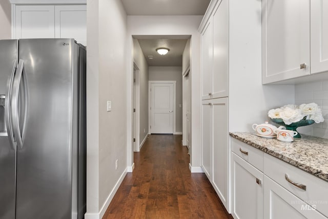 hallway with baseboards and dark wood-style flooring