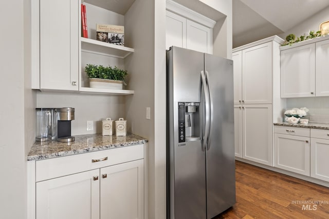 kitchen with open shelves, wood finished floors, light stone countertops, white cabinetry, and stainless steel fridge with ice dispenser
