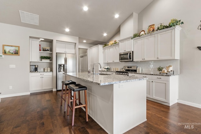 kitchen with open shelves, appliances with stainless steel finishes, a sink, visible vents, and dark wood-style floors