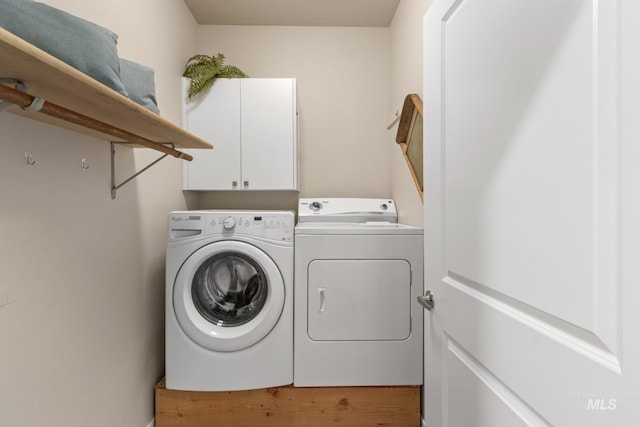 laundry room featuring independent washer and dryer and cabinet space