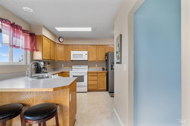 386 E Valleyview Ave, Genesee, ID 83832 - kitchen featuring white appliances, a sink, a peninsula, a kitchen bar, and light countertops