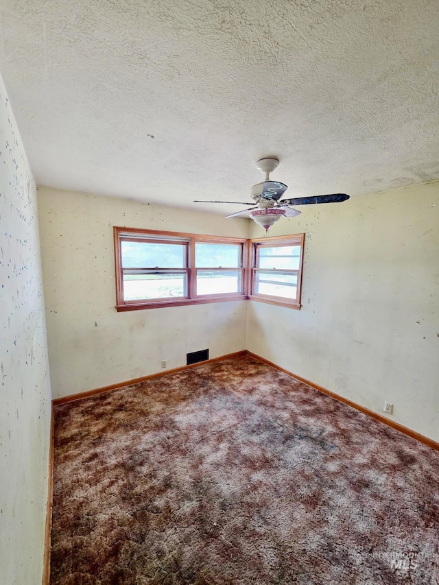 unfurnished room with plenty of natural light, carpet flooring, a ceiling fan, a textured ceiling, and baseboards