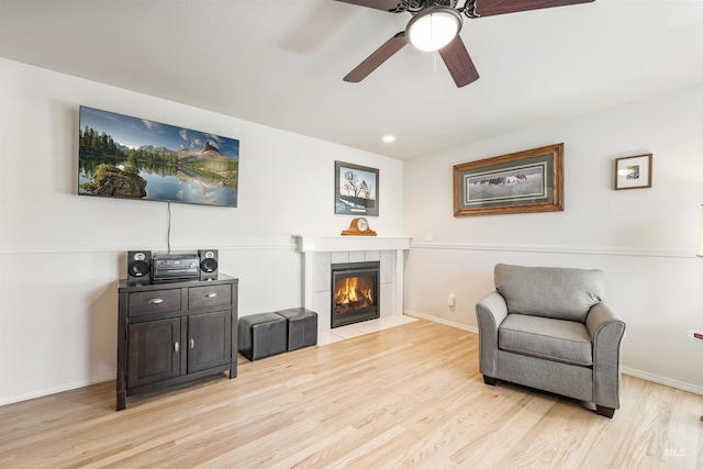 1177 N Lopez Ave, Eagle, ID 83616 - sitting room with light wood-style flooring, ceiling fan, a tile fireplace, and baseboards
