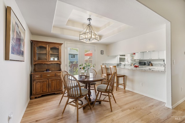 1177 N Lopez Ave, Eagle, ID 83616 - dining area featuring a raised ceiling, light wood finished floors, a chandelier, and baseboards