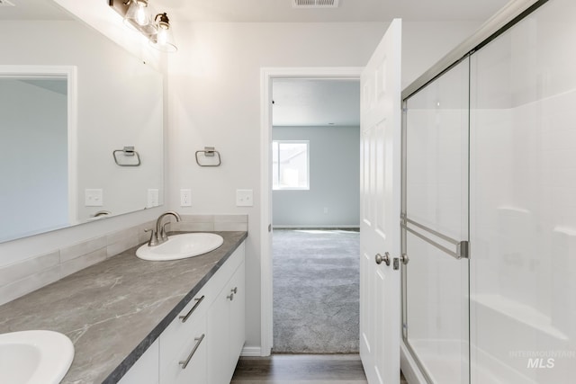 13729 Higley Ct, Caldwell, ID 83607 - bathroom featuring double vanity, a shower with door, and wood finished floors