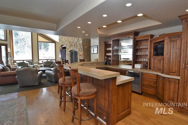 221 Picabo Street #I, Interest 6-C, Ketchum, ID 83340 - kitchen with open floor plan, light countertops, a tray ceiling, light wood-style floors, and beverage cooler