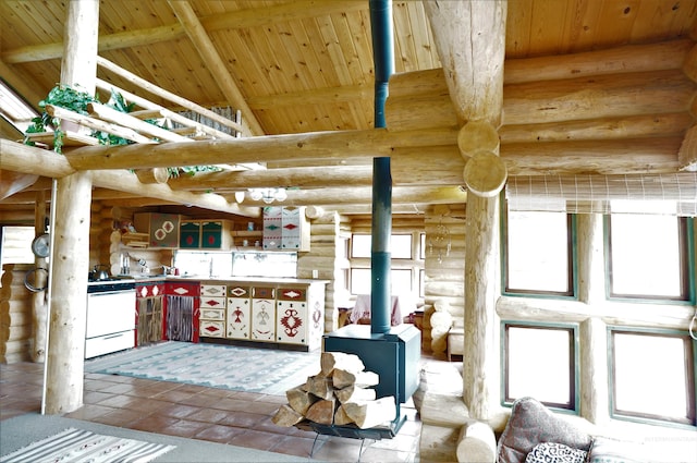 kitchen with log walls, light tile floors, wood ceiling, beam ceiling, and a wood stove