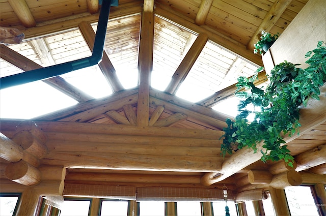 room details with rustic walls, beamed ceiling, and wooden ceiling