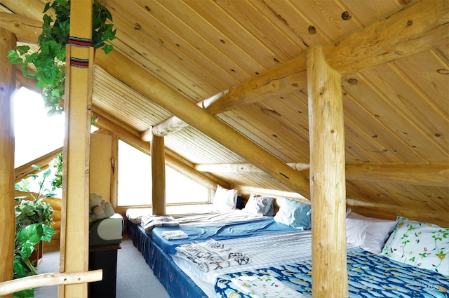 bedroom featuring lofted ceiling with beams, wooden ceiling, and carpet