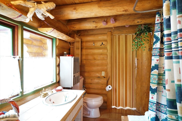 bathroom with oversized vanity, log walls, and toilet