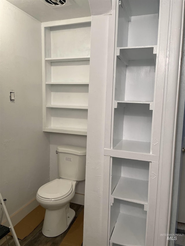 bathroom featuring baseboards, toilet, and wood finished floors