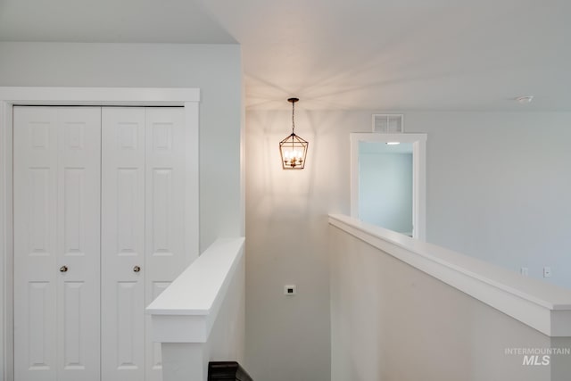 staircase with a chandelier