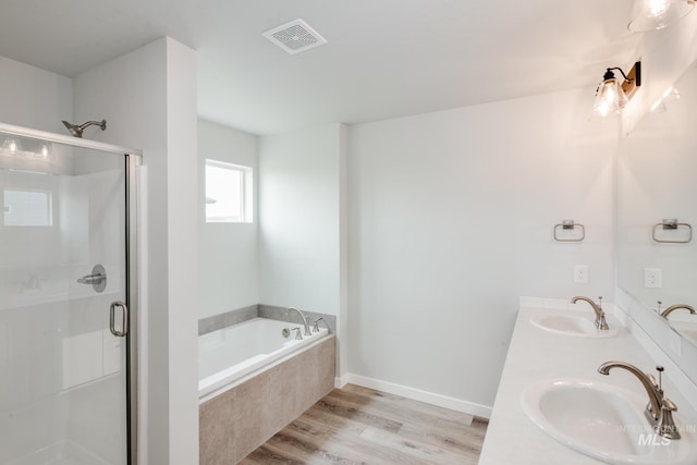 bathroom with hardwood / wood-style floors, vanity, and plus walk in shower