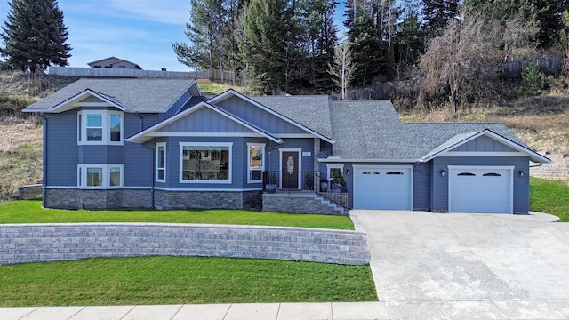 craftsman inspired home with board and batten siding, a garage, a front yard, and concrete driveway