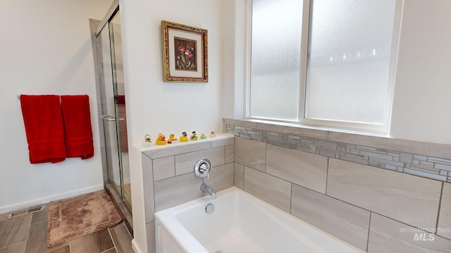 full bathroom featuring a shower stall, visible vents, and a garden tub