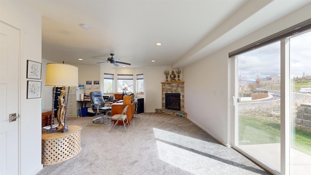 office with a stone fireplace, a ceiling fan, light colored carpet, and recessed lighting