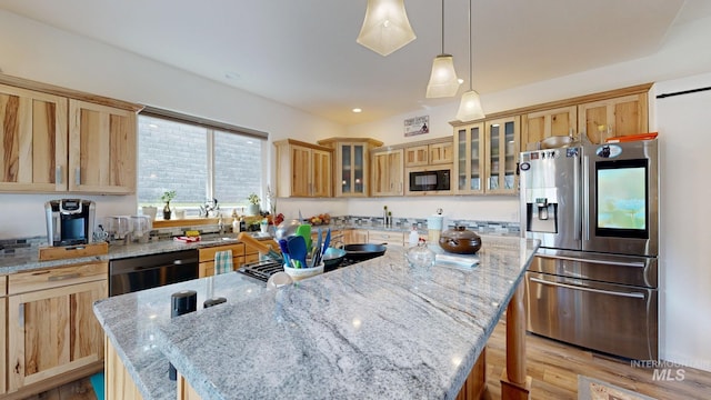 kitchen featuring light stone countertops, light brown cabinets, black appliances, and a kitchen island