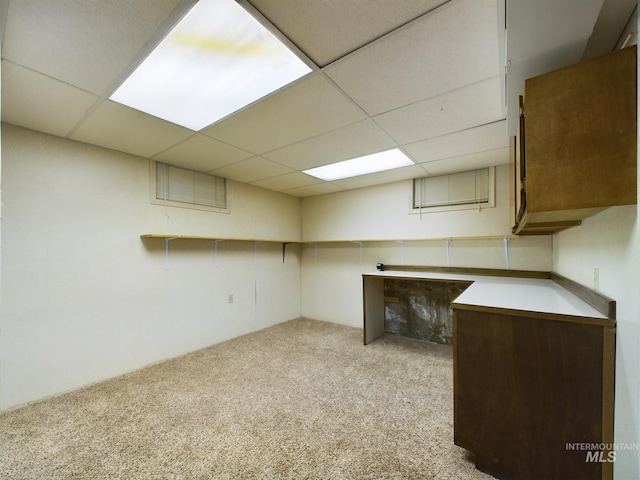 basement with light colored carpet and a paneled ceiling