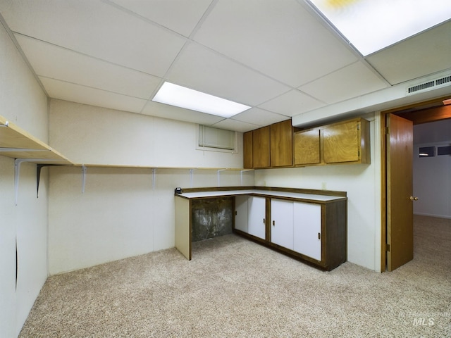 basement with light carpet and a drop ceiling