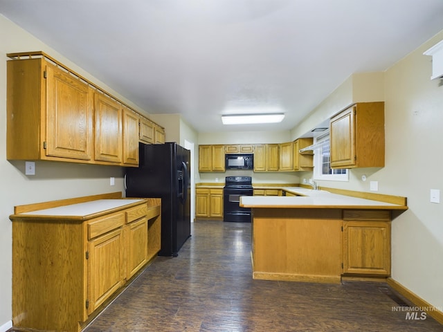 kitchen featuring dark hardwood / wood-style flooring, sink, black appliances, and kitchen peninsula