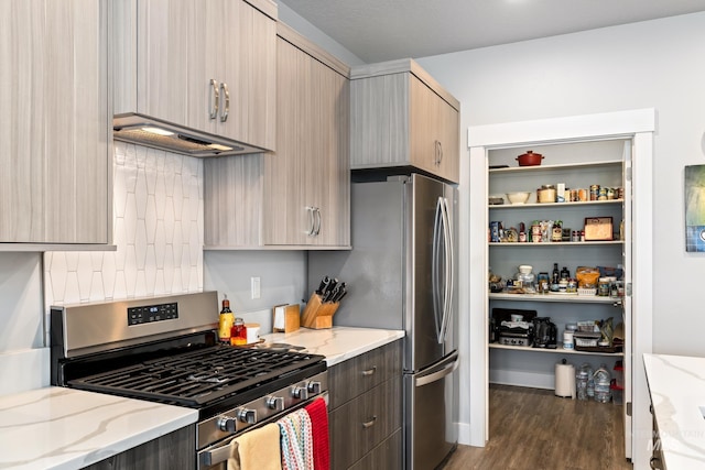 kitchen featuring appliances with stainless steel finishes, light brown cabinetry, light stone counters, and premium range hood