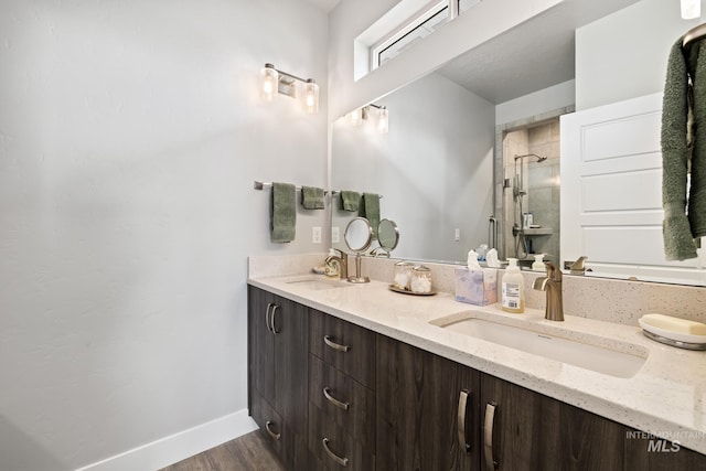 bathroom featuring wood-type flooring, vanity, and a shower