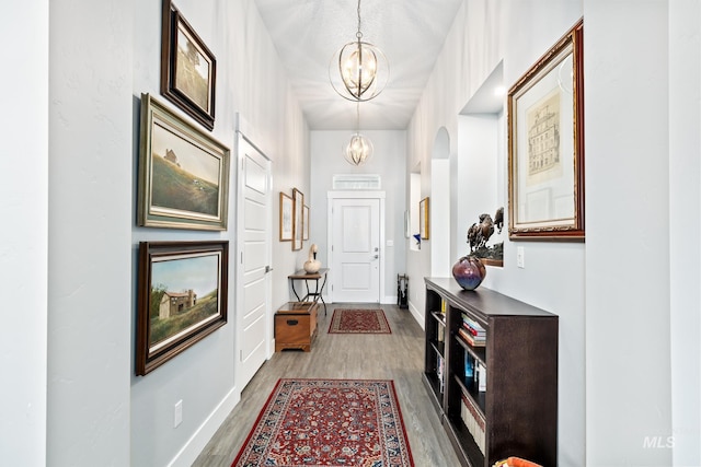 foyer entrance featuring wood-type flooring and a chandelier