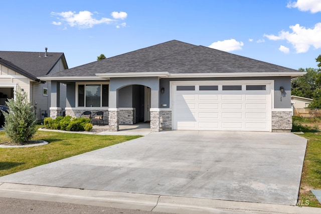 view of front of property featuring a front yard, a garage, and a porch