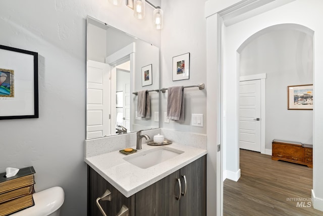 bathroom featuring hardwood / wood-style flooring, vanity, and toilet