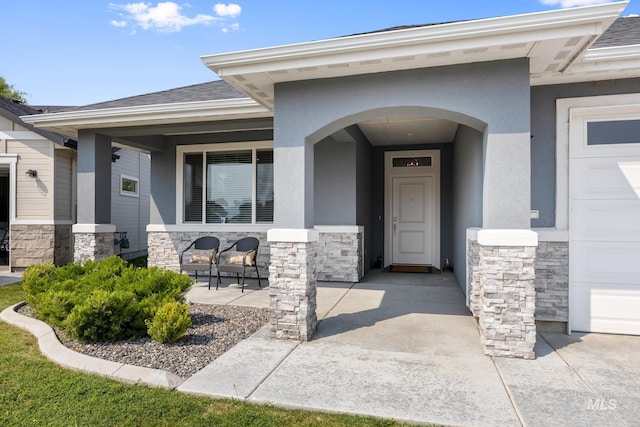 doorway to property with covered porch and a garage