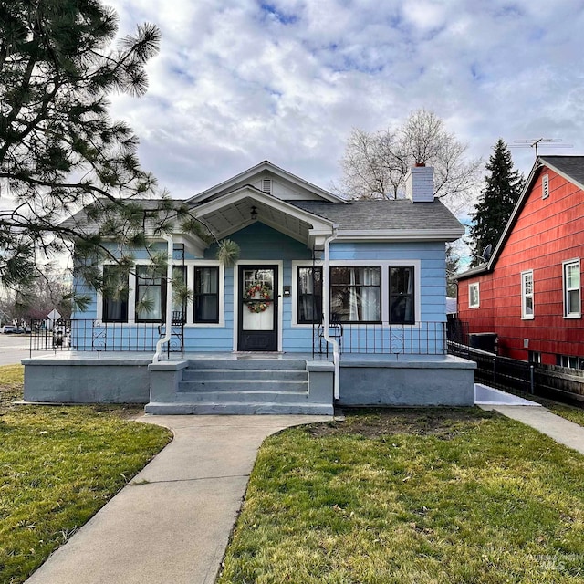 bungalow-style house with covered porch and a front yard