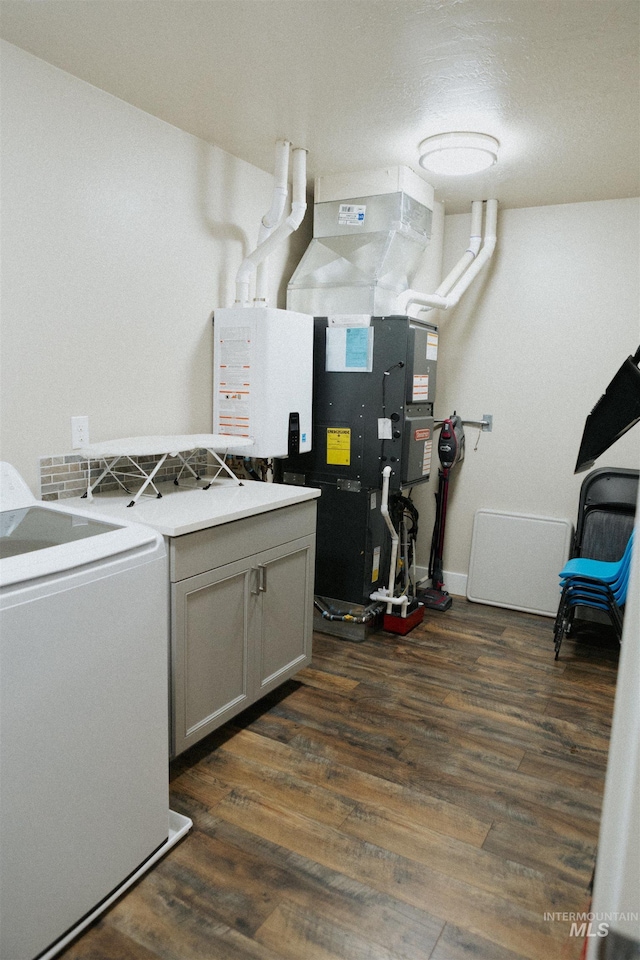 washroom featuring washer / clothes dryer, dark wood-type flooring, and cabinets