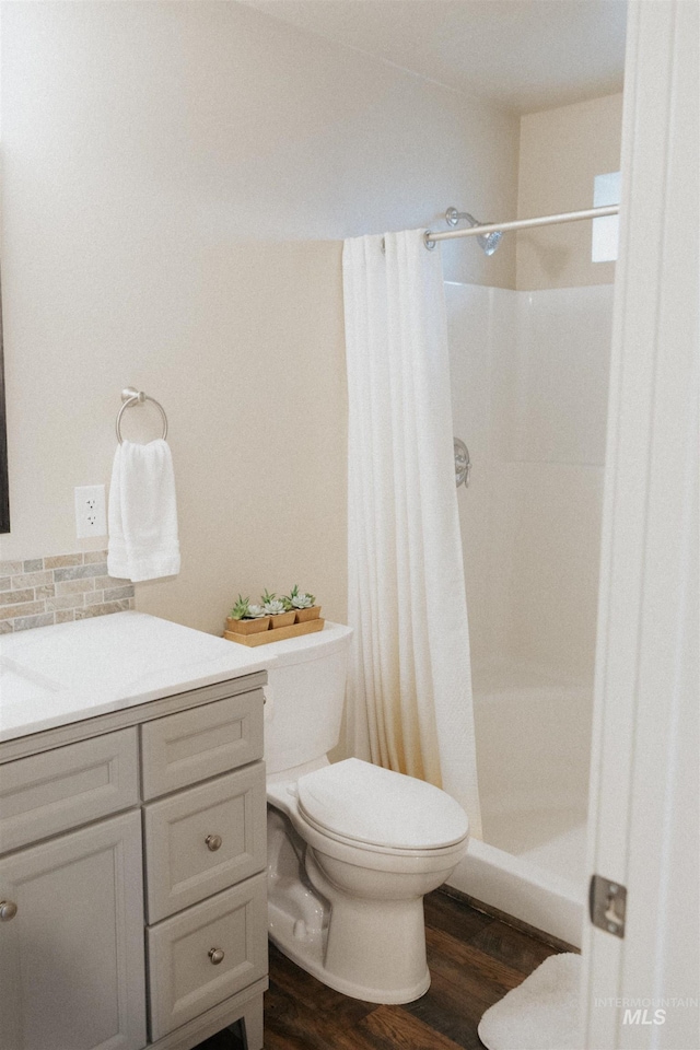 bathroom featuring hardwood / wood-style flooring, toilet, and curtained shower