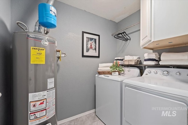 clothes washing area with cabinet space, washing machine and dryer, water heater, and baseboards