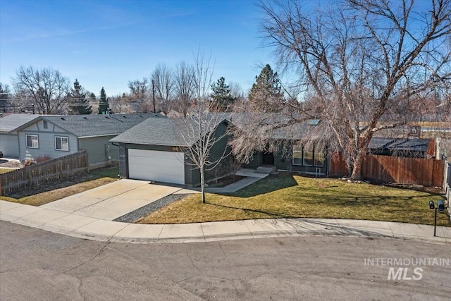 ranch-style house featuring an attached garage, driveway, a front yard, and fence