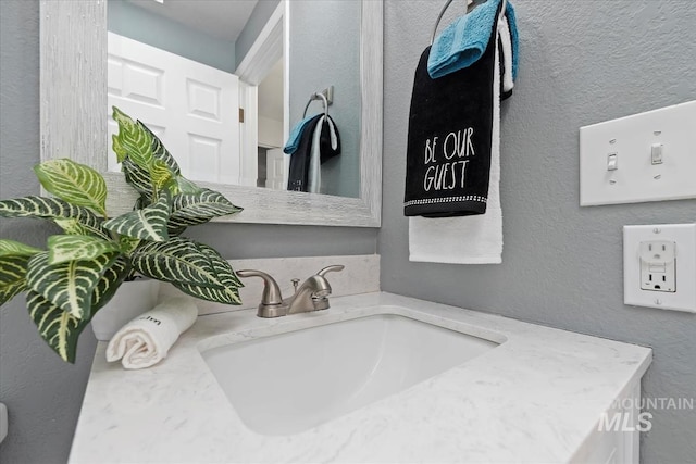 interior details with a textured wall and vanity