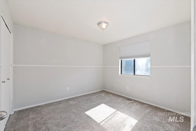 spare room with carpet and baseboards