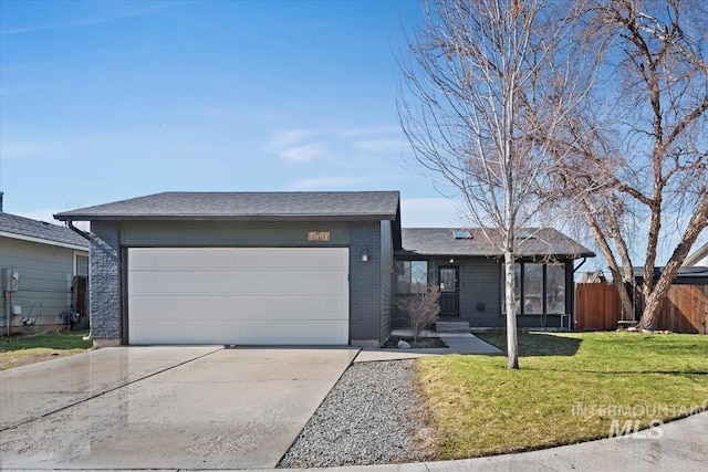 view of front of property featuring brick siding, a front yard, fence, a garage, and driveway